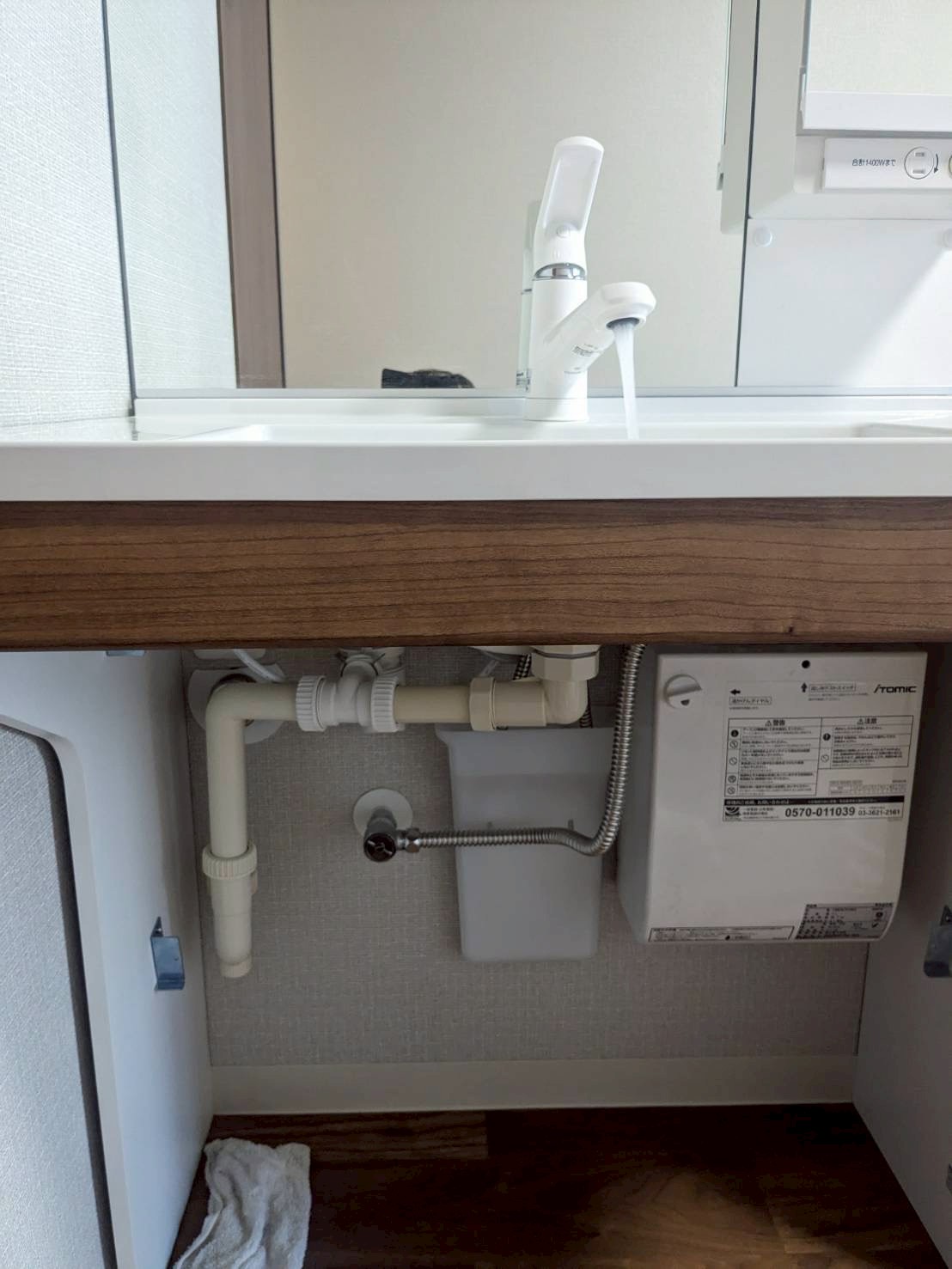 洗面台下の給排水設備の写真